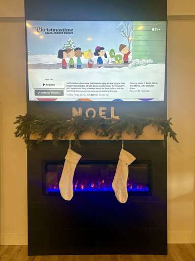 Festive Fireplace, Stockings Hanging, Seasonal Signage, Blue Blaze Below Festive Fireplace, Stockings Hanging, Seasonal Signage, Blue Blaze Below