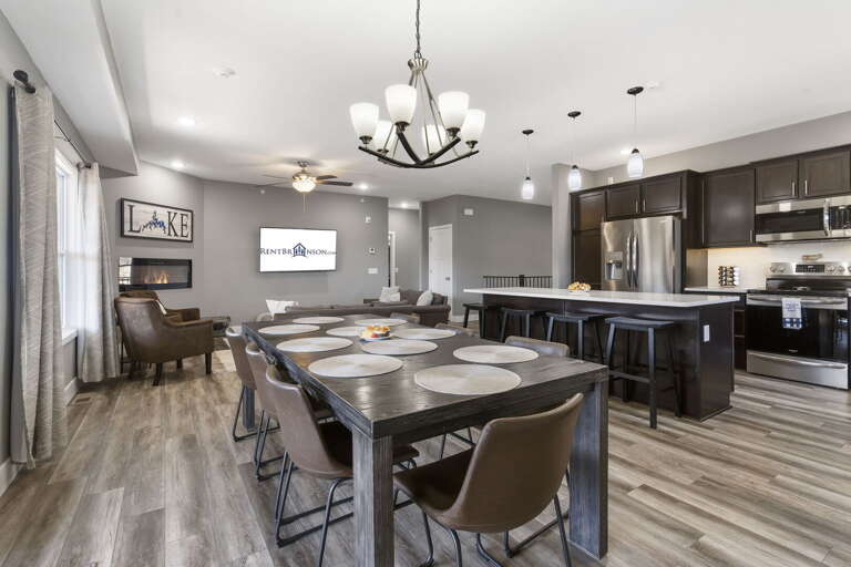Interior View Of A Dining Area Leading To A Kitchen With A Chandelier Overhead
