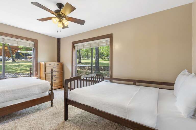 Beige Bedroom With Two Beds Bordered By Big Windows Showcasing Green Garden Glance