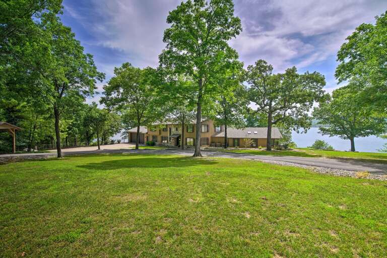 Rural House Surrounded By Trees With A Lake In The Background