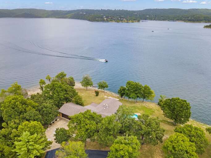 Lakeside Property With Boat And Greenery