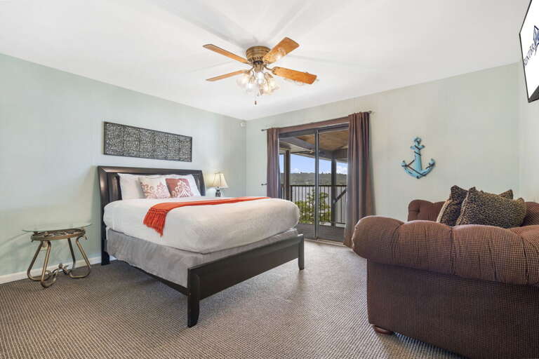 Spacious Sleeping Space With Ceiling Fan, Balcony Access, Beige Sofa