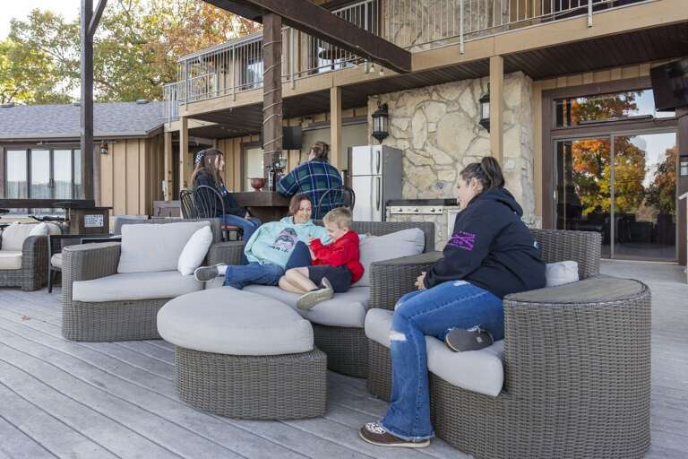 Group Gathering On Grey Sofas Outside A Vacation Rental