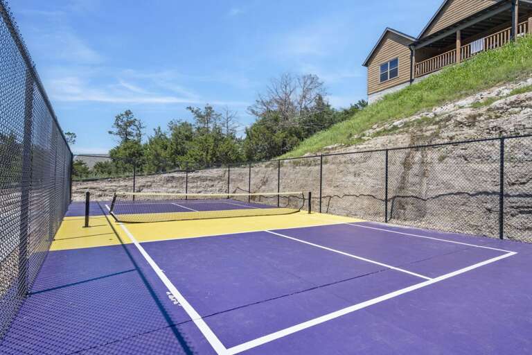 Outdoor Tennis Court With Surrounding Fence And House
