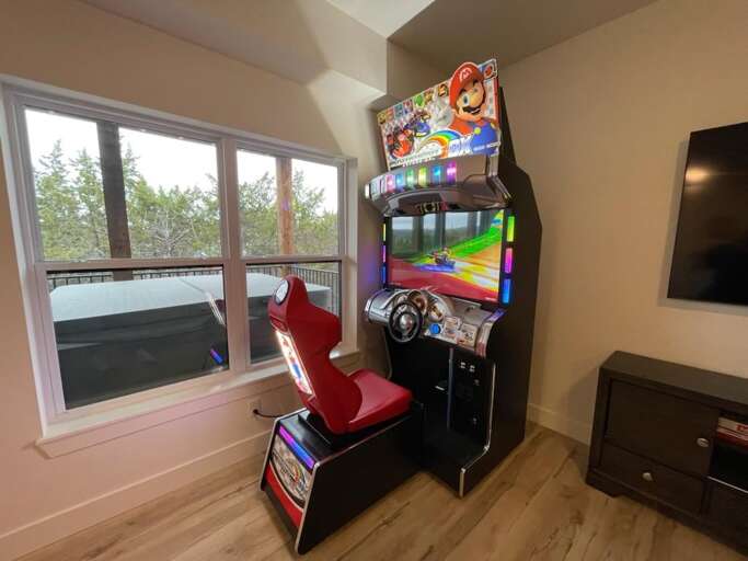 Bright Room With Arcade Game And Mounted TV, Trees Visible Through Window