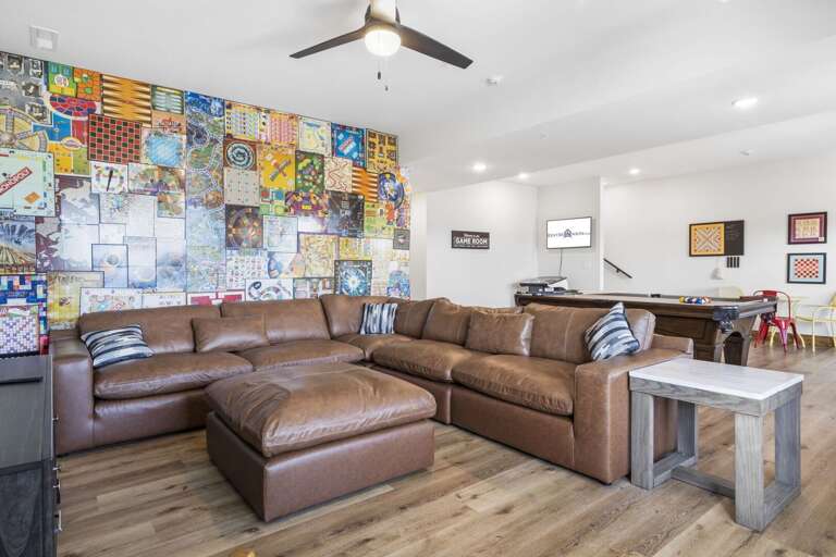 Spacious Living Room With Sectional Sofa, Artwork, And Pool Table
