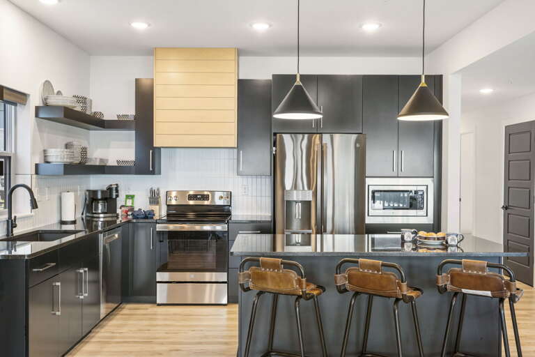 Stylish Kitchen Interior With Island And Stainless Steel Appliances