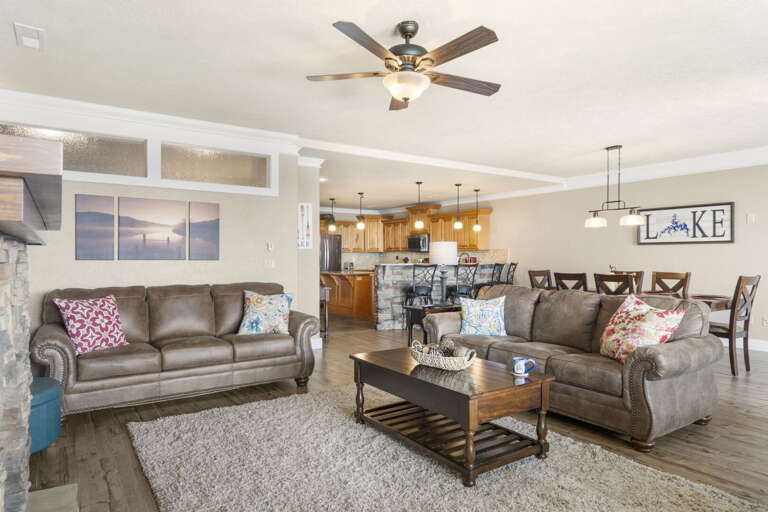 Living Room With Sofas, Coffee Table, And Dining Area In Background