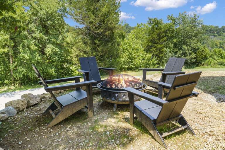 Outdoor Seating Area With Fire Pit And Chairs Surrounded By Trees
