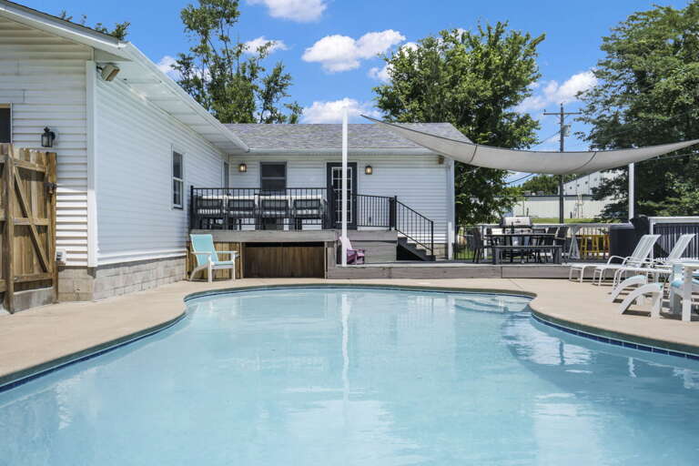 Swimming Pool At A Vacation Rental With Chairs And Building In The Background