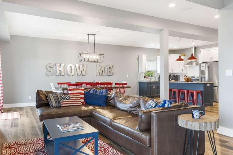 Living Room Interior With Couch, Cushions, And Kitchen In Background Living Room Interior With Couch, Cushions, And Kitchen In Background