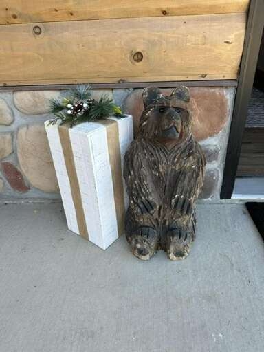 Bear Sculpture Beside Boxed Gift By Building