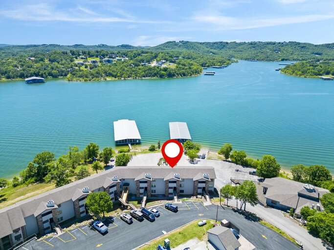 Aerial View Of Lakeside Buildings With Red Location Marker Aerial View Of Lakeside Buildings With Red Location Marker