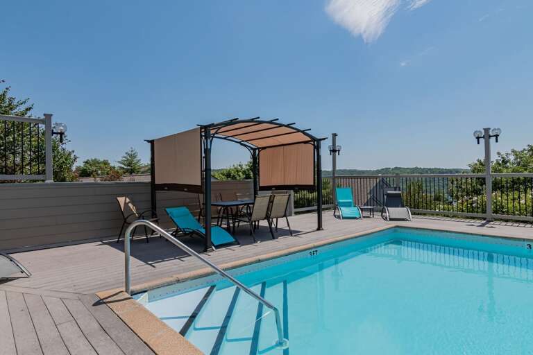 Swimming Pool With Chairs, Canopy, And Scenic Sky View