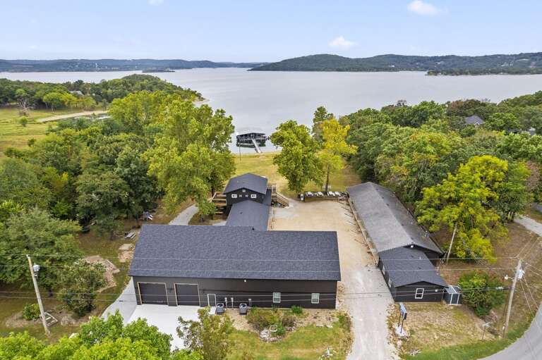 Aerial View Of Lakeside Lodging Buildings Surrounded By Green Landscape