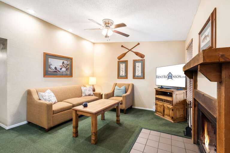 Living Room With Lush Green Carpet, Creamy Couches, And A Flickering Fireplace Living Room With Lush Green Carpet, Creamy Couches, And A Flickering Fireplace