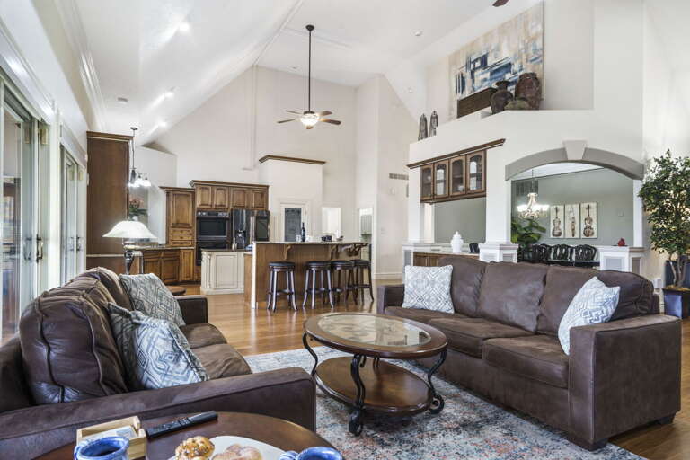 Spacious Living Room Leading To Kitchen In A Vacation Rental With Vaulted Ceiling And Plush Sofas Spacious Living Room Leading To Kitchen In A Vacation Rental With Vaulted Ceiling And Plush Sofas