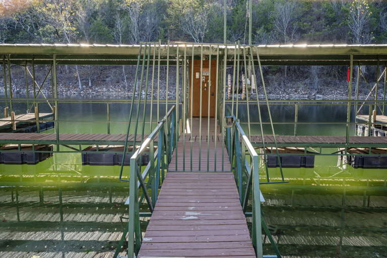Wooden Walkway Leading To Suspended Fishing Platforms On Tranquil Green Lake Wooden Walkway Leading To Suspended Fishing Platforms On Tranquil Green Lake
