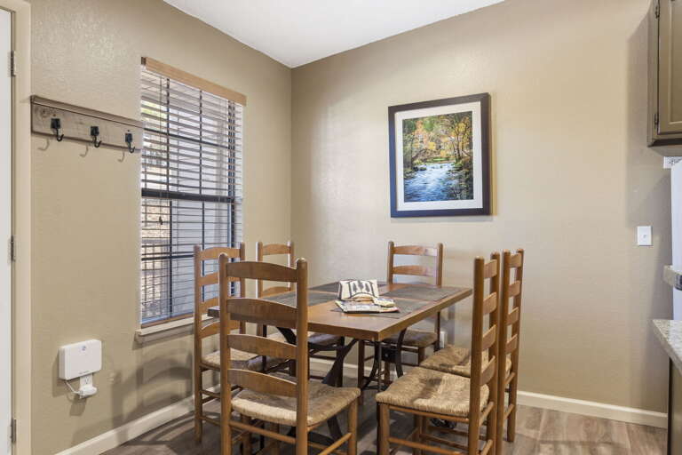 Wooden Table Set In Small Dining Space With Picture On Wall