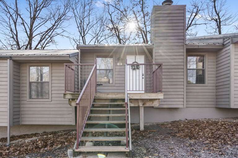 Beige Building With Balcony And Bare Branches Behind Beige Building With Balcony And Bare Branches Behind