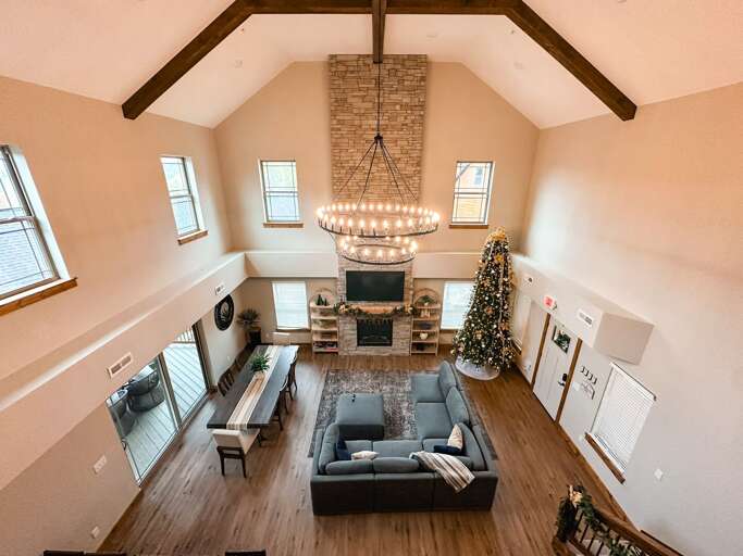 Lofty Living Space Lit By Large Windows, Lavish Lights, And Luxe Leather Lounging