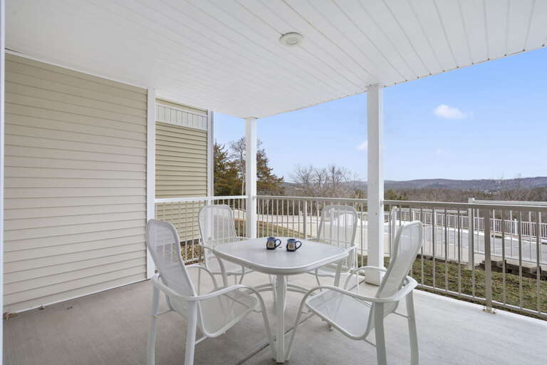 White Patio Furniture On Balcony Overlooking Lake