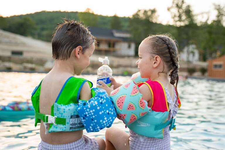 Children Sharing Water Bottle Near Vacation Rental, Gentle Lake Gleaming