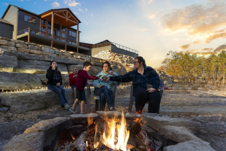 Family Grilling Marshmallows By Firepit, Stone Steps And Structure Background