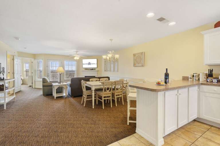 Spacious Living Room With Dining Table, Kitchen Counter, And Soft Lighting