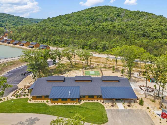 Aerial View Of A Large Building Near A Lush, Rolling Ridge