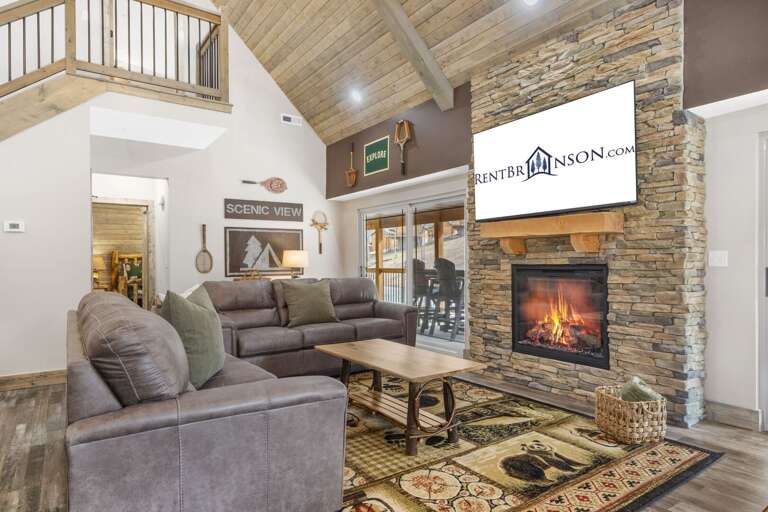 Spacious Living Area With A Stone Fireplace And Vaulted Ceiling