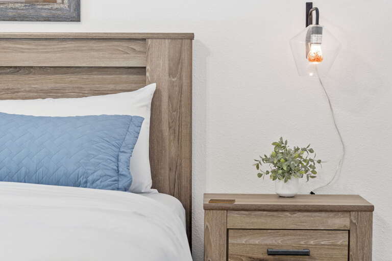 Bedside Bliss With Bulb, Blue Bedding, And Botanical