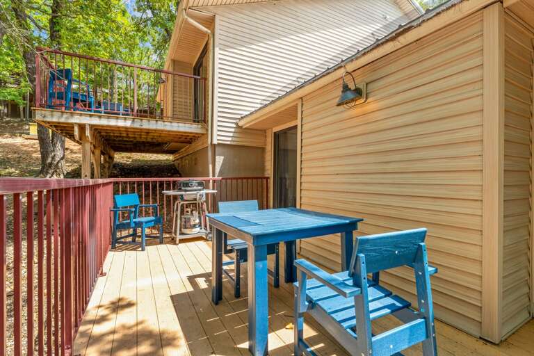 Wooden Vacation Rental With Spacious Deck And Blue Furniture Under Shaded Trees