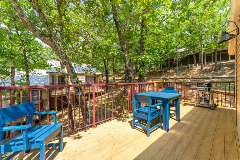 Rustic Retreat, Raised Red Railing, Relaxing Blue Benches Surrounded By Lush Leaves