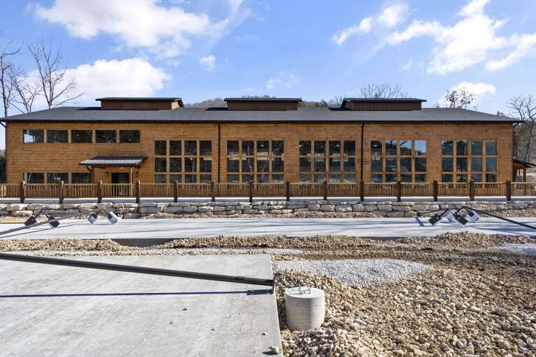 Large, Luminous Lodge, Lined With Vast Windows Set Against A Serene Sky