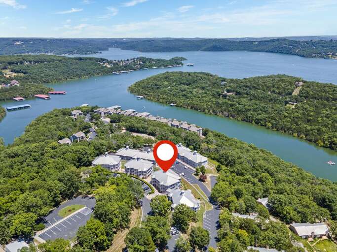 Aerial View Of Lakeside Lodging Cluster, Surrounded By Lush Landscapes And Serene Water