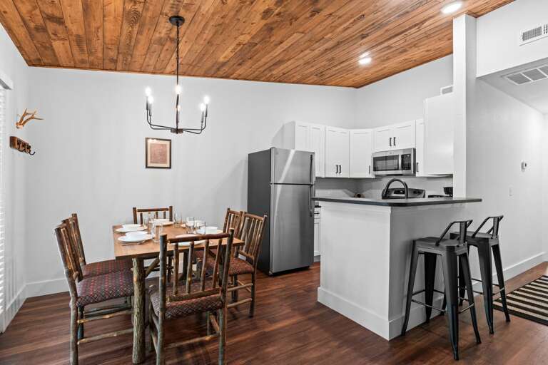 Interior Kitchen And Dining Area With Wooden Ceiling And White Walls