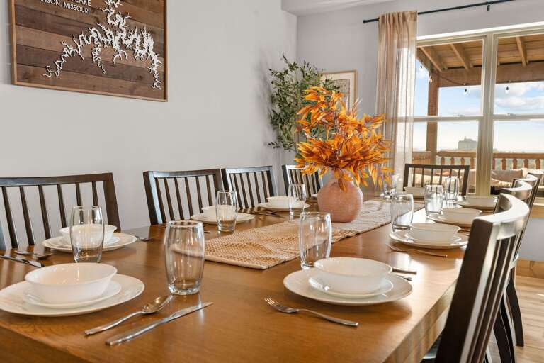 Dining Area With Striped Seats, Set Table, And Vibrant Vase Flowers