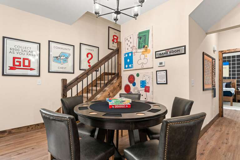 Game Room With Round Table, Framed Art, And Staircase