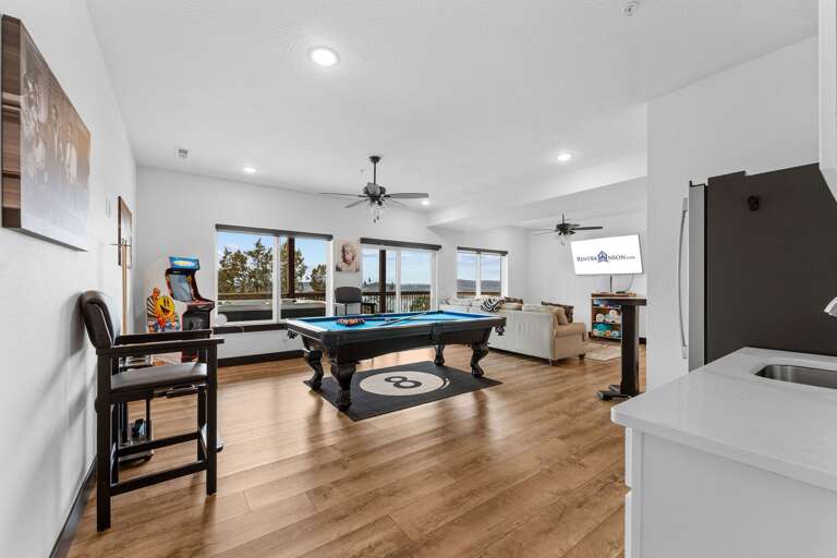 Spacious Room With Pool Table, Plush Seating, And Large Windows