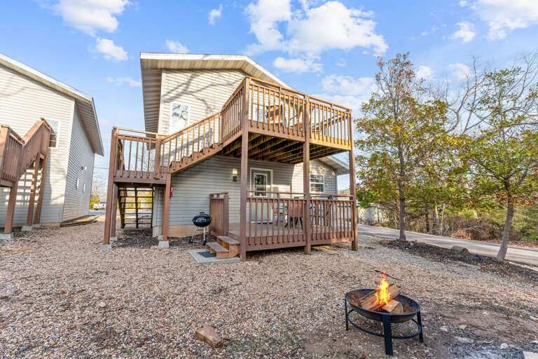 Wooden Decked Dwelling With Burning Fire Pit And Clear Sky
