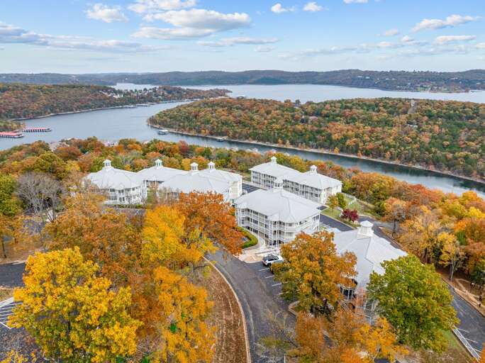 Buildings Beside A Beautiful, Bending Bay Amidst Autumnal Trees