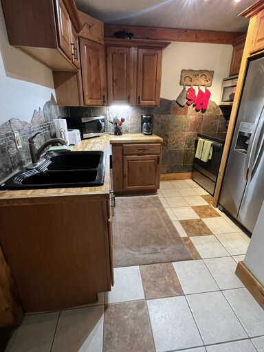 Kitchen is compact but well appointed with stainless fridge