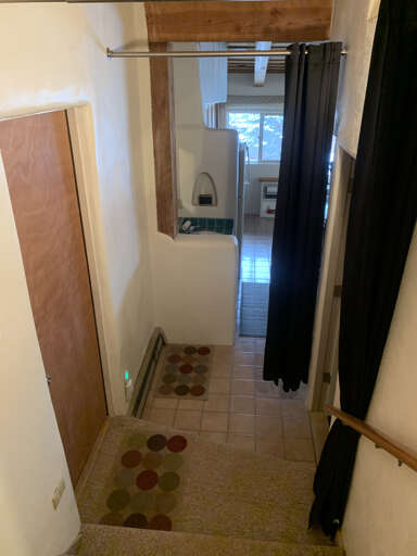Kitchen View through Entry and bath area with sleeping loft to right