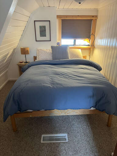 Curl up in this peaceful bedroom featuring crisp linens, soft lighting, and charming wood accentsâyour perfect retreat for restful nights.