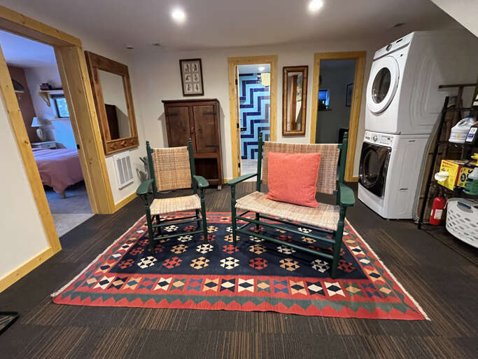 A spacious lower-level sitting area with charming woven furniture, colorful textiles, and handy washer/dryer units keeps your stay effortless and comfortable.