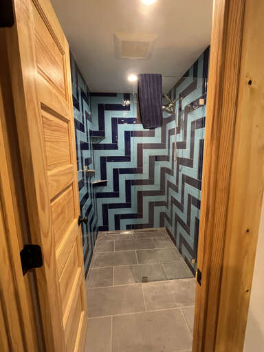 Step into your private oasis with bold geometric tiles and a sleek walk-in shower, where modern design meets total relaxation.