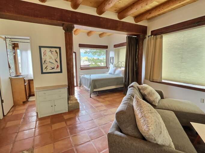 Main queen bed in sleeping area with privacy curtain to separate from the living spaces shades down