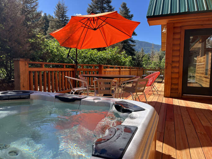 New wood deck with shaded patio dining, and hot tub