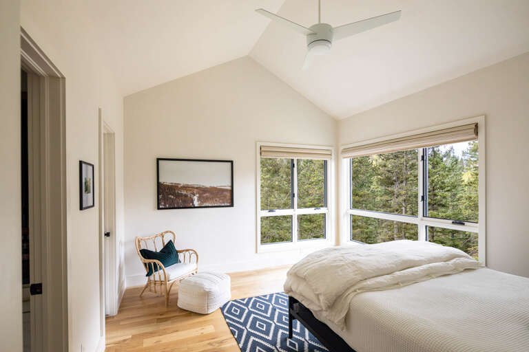 Beautiful queen bedroom with ensuite bath and closet, mountains outside large windows.